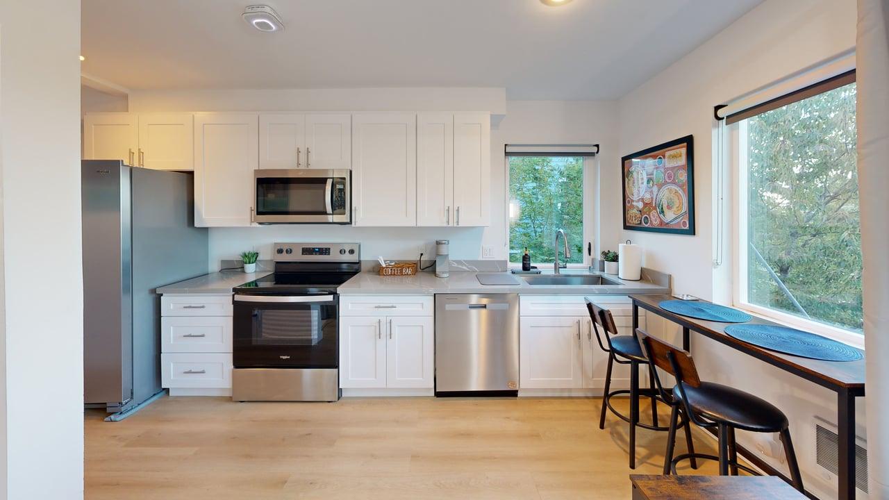 Full kitchen with white cabinetry and window seating