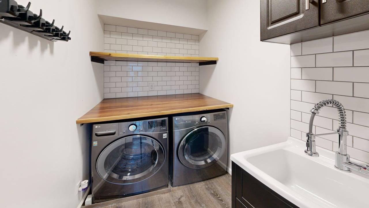 Private laundry room with washer, dryer, and utility sink
